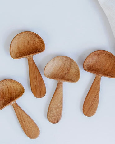 Hand-carved wooden mushroom scoop with rounded cap and smooth handle, photographed on a white background.