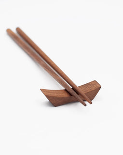 9-inch walnut chopsticks resting on a matching walnut chopstick rest, photographed on a white background.