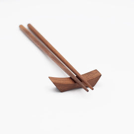 9-inch walnut chopsticks resting on a matching walnut chopstick rest, photographed on a white background.