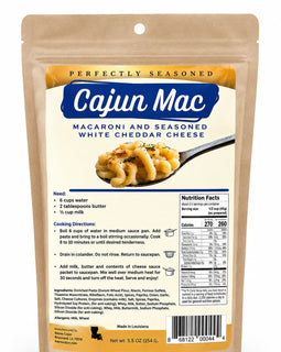 A stand-up pouch of Cajun Mac macaroni and seasoned white cheddar cheese on a plain white background. The package is tan with a large blue brand panel and an image of the cheesy pasta on a spoon.