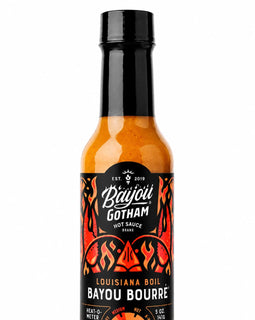 A 5 oz bottle of Bayou Gotham Louisiana Boil Bayou Bourré hot sauce, featuring an orange-red sauce inside a clear glass bottle with a black cap and a black label with red and white graphics.