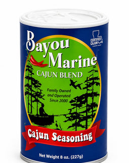 Bayou Marine Cajun Blend seasoning in an 8 oz metal can, featuring a blue label with a green central circle, black tree silhouettes, and a red banner reading 'Cajun Seasoning'.
