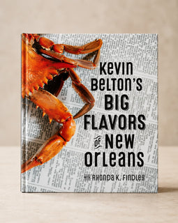The front cover of the book 'Kevin Belton's Big Flavors of New Orleans' by Rhonda K. Findley, featuring a large cooked crab on a newspaper background, shown standing upright against a neutral beige background.