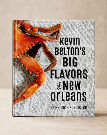 The front cover of the book 'Kevin Belton's Big Flavors of New Orleans' by Rhonda K. Findley, featuring a large cooked crab on a newspaper background, shown standing upright against a neutral beige background.