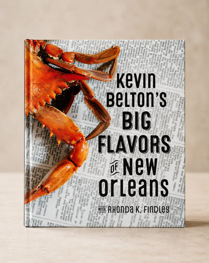 The front cover of the book 'Kevin Belton's Big Flavors of New Orleans' by Rhonda K. Findley, featuring a large cooked crab on a newspaper background, shown standing upright against a neutral beige background.