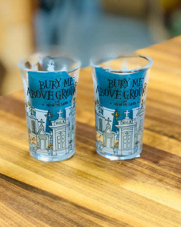 Shot glass with illustrated New Orleans above-ground tombs and the phrase ‘Bury Me Above Ground in New Orleans.’