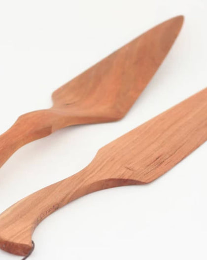 Handcrafted cherry wood cake knife and server set on white background.
