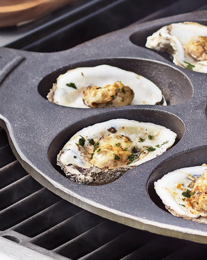 Oysters in an oyster pan on a grill