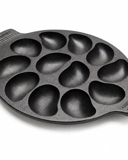 A black cast iron 10 oyster pan with teardrop-shaped cavities, shown on a clean white background. 