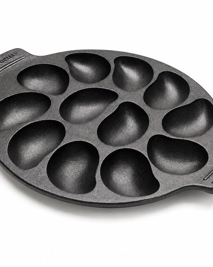 A black cast iron 10 oyster pan with teardrop-shaped cavities, shown on a clean white background. 