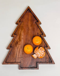 “Wooden Christmas tree–shaped serving board with carved groove, shown with oranges on top.”
