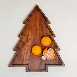 “Wooden Christmas tree–shaped serving board with carved groove, shown with oranges on top.”
