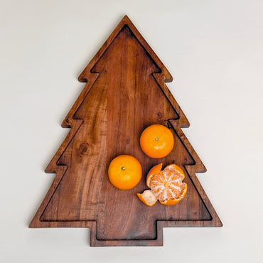 “Wooden Christmas tree–shaped serving board with carved groove, shown with oranges on top.”
