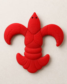 A bright red lcrawfish baby teether shown on a light beige textured background.