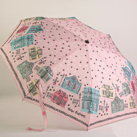 Pink travel umbrella featuring illustrated New Orleans Creole cottages and architectural homes with wrist strap displayed open.