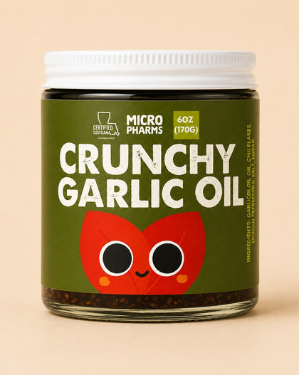 A jar of Micropharmes Crunchy Garlic Oil with a dark olive green label, white cap, and a red cartoon garlic bulb graphic, set against a solid beige background.