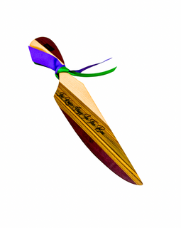 Tricolored wooden king cake knife handmade by NOLA Boards with Purple Heart, Sinker Cypress, and Maple featuring engraved king cake rule and Mardi Gras ribbon.