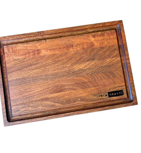 Handcrafted walnut cutting board with deep juice groove and NOLA Boards logo, size 12x18 inches.