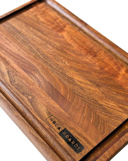Handcrafted walnut cutting board with deep juice groove and NOLA Boards logo, size 12x18 inches.