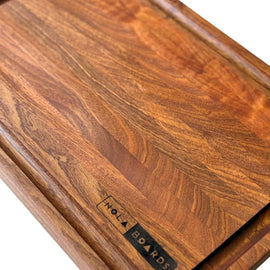 Handcrafted walnut cutting board with deep juice groove and NOLA Boards logo, size 12x18 inches.