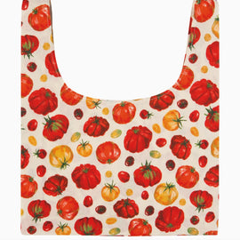 A reusable tote bag with a printed pattern of red, orange, and yellow tomatoes on an off-white background.