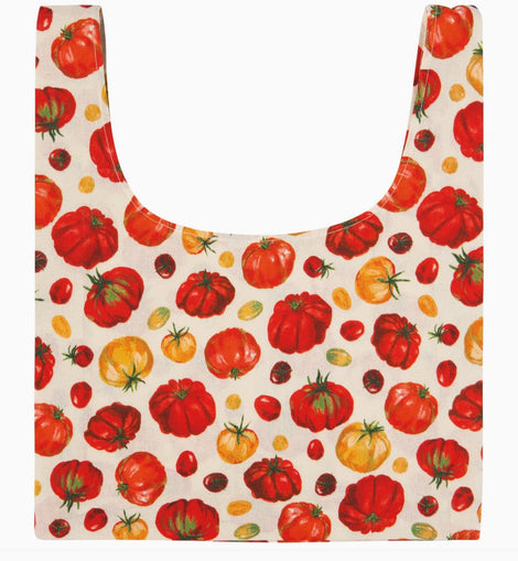 A reusable tote bag with a printed pattern of red, orange, and yellow tomatoes on an off-white background.
