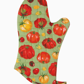 Quilted cotton oven mitt with heirloom tomato print in red and yellow tones hanging on kitchen rack with wooden utensils nearby.