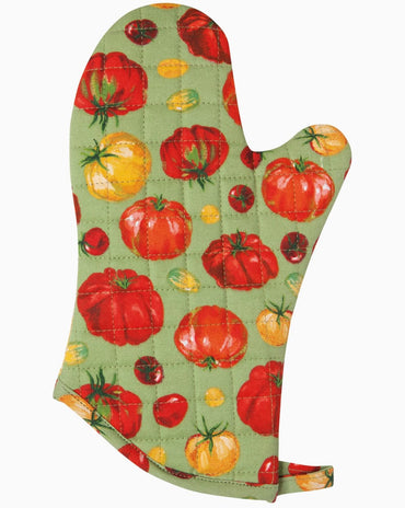 Quilted cotton oven mitt with heirloom tomato print in red and yellow tones hanging on kitchen rack with wooden utensils nearby.