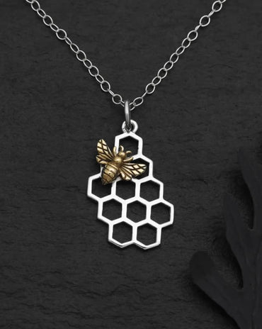 Silver honeycomb pendant necklace with a detailed bronze honeybee on a delicate silver chain.