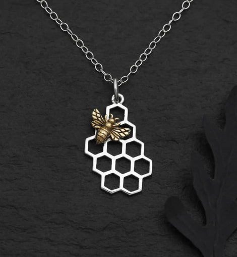 Silver honeycomb pendant necklace with a detailed bronze honeybee on a delicate silver chain.