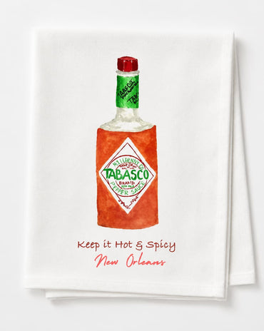 A white kitchen towel featuring a watercolor-style illustration of a Tabasco bottle with the text 'Keep it Hot & Spicy New Orleans' printed below, shown on a clean white background.