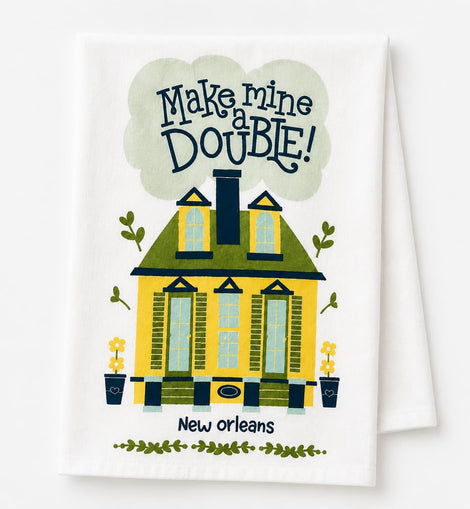 A white kitchen towel featuring a colorful illustration of a yellow house with green trim, the text 'Make mine DOUBLE!' in a cloud above, and 'New orleans' below.
