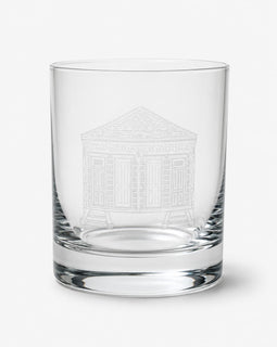 A clear glass rocks tumbler featuring an etched white line drawing of a classical building on the front, set against a plain light gray background.
