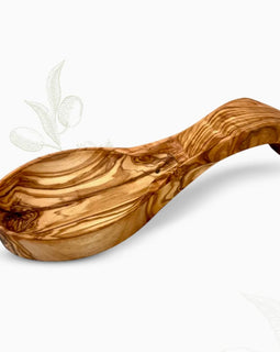 Hand-carved olive wood spoon rest with curved bowl and rich natural grain on a white background.