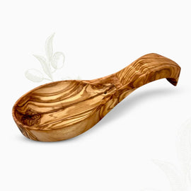 Hand-carved olive wood spoon rest with curved bowl and rich natural grain on a white background.