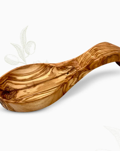 Hand-carved olive wood spoon rest with curved bowl and rich natural grain on a white background.