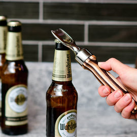 Pakka wood handle bottle opener with stainless steel head resting on a wooden surface