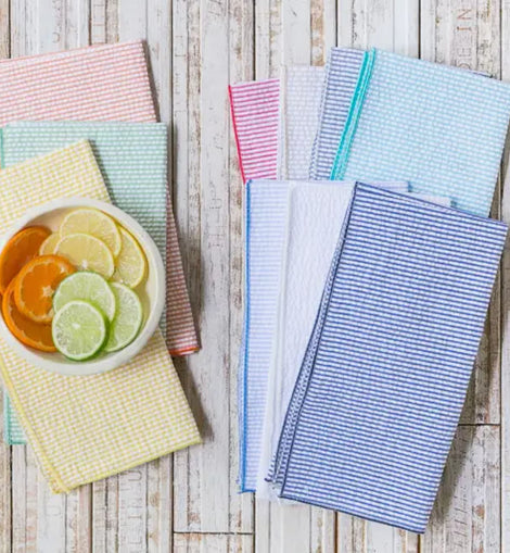 Set of four blue and white seersucker cotton dinner napkins folded on table various colors