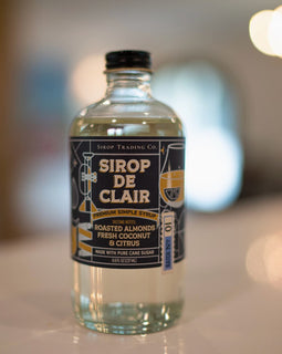 Bottle of Sirop Trading Co Sirop de Clair premium simple syrup with roasted almond, coconut, and citrus tasting notes, handcrafted in South Louisiana.