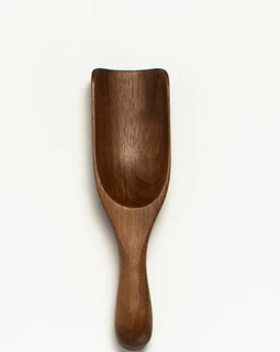 Small 5-inch walnut wood scoop with curved bowl and rounded handle.