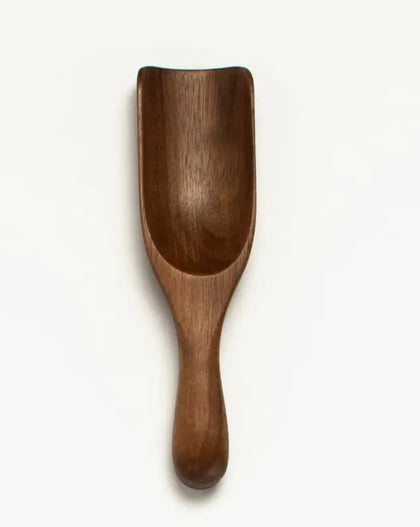 Small 5-inch walnut wood scoop with curved bowl and rounded handle.