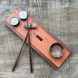 Handcrafted wooden sushi set on Tracks board with mini wooden bowl, wooden chopsticks, and chopstick rest, branded NOLA Boards.
