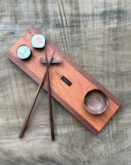 Handcrafted wooden sushi set on Tracks board with mini wooden bowl, wooden chopsticks, and chopstick rest, branded NOLA Boards.