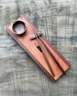 Handcrafted wooden sushi set on Tracks board with mini wooden bowl, wooden chopsticks, and chopstick rest, branded NOLA Boards.