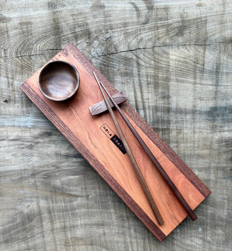 Handcrafted wooden sushi set on Tracks board with mini wooden bowl, wooden chopsticks, and chopstick rest, branded NOLA Boards.