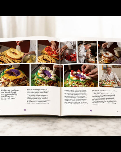 An open cookbook spread displayed on a light marble surface against a white background. The pages feature multiple color food photographs, a quote on the left page, and two columns of text.