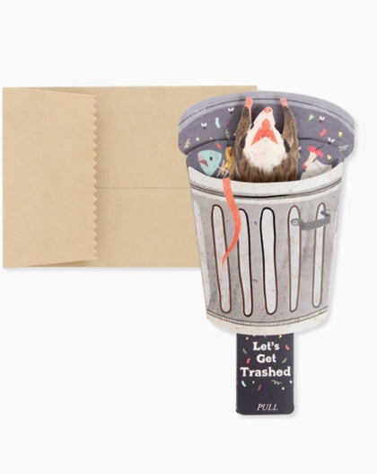 Trash possum mini pop-up greeting card featuring a possum popping out of a trash can with a pull tab that reads “Let’s Get Trashed.”