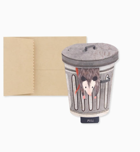 Trash possum mini pop-up greeting card featuring a possum popping out of a trash can with a pull tab that reads “Let’s Get Trashed.”