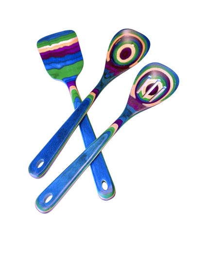 Three colorful tropical rainbow laminated-wood utensils—spatula, solid spoon, and slotted spoon—featuring blue, green, purple, and pink layers.