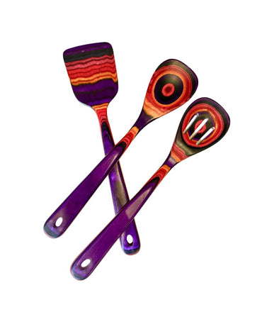 hree colorful layered-wood kitchen utensils—spatula, solid spoon, and slotted spoon—in purple, red, and orange tones on white background.